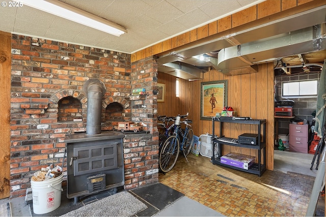 basement featuring wood walls and a wood stove