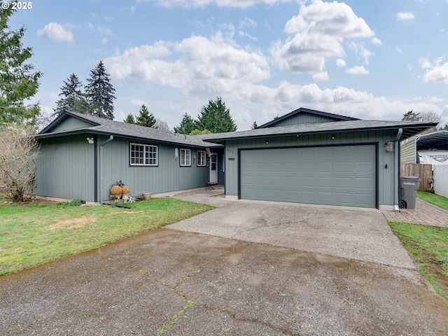 ranch-style house with a garage, concrete driveway, and a front lawn