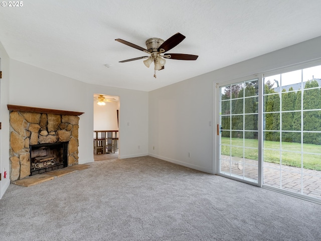 unfurnished living room featuring a ceiling fan, a textured ceiling, carpet floors, a fireplace, and baseboards