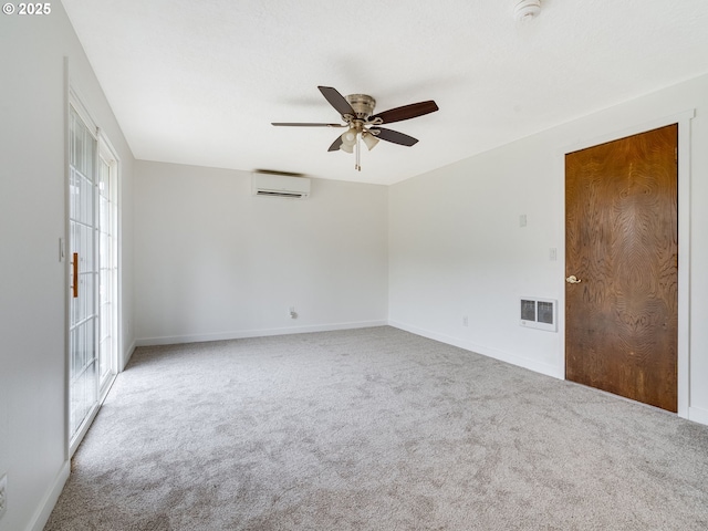 empty room with visible vents, carpet flooring, a wall mounted air conditioner, and a ceiling fan