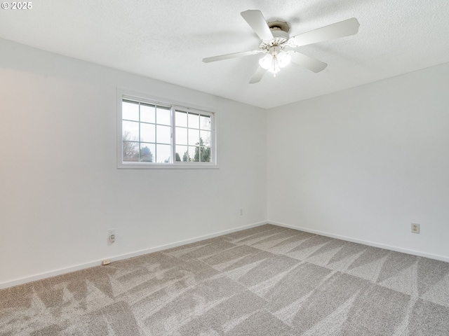 empty room with ceiling fan, a textured ceiling, baseboards, and carpet floors