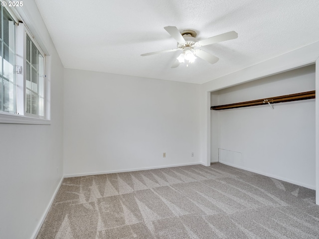 unfurnished bedroom with ceiling fan, a textured ceiling, baseboards, and carpet floors