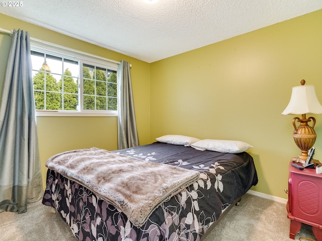 carpeted bedroom with baseboards and a textured ceiling