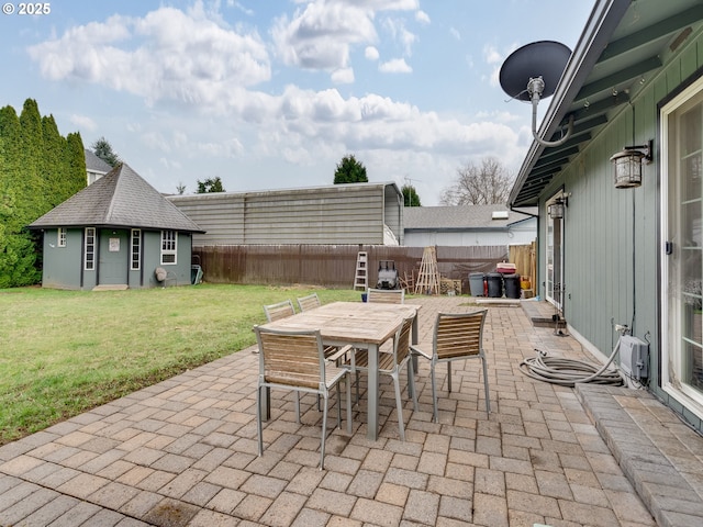 view of patio featuring an outbuilding, a fenced backyard, and outdoor dining space