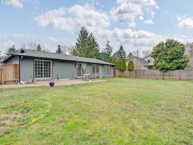 back of property featuring a lawn, a fenced backyard, and a patio area