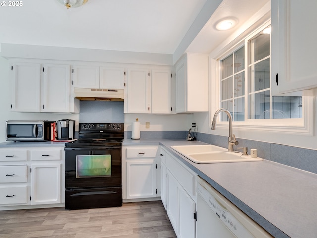 kitchen featuring stainless steel microwave, under cabinet range hood, dishwasher, black electric range, and a sink