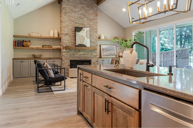 1718 SE 40th St, Brush Prairie, WA 98606 - kitchen with stainless steel dishwasher, a fireplace, light wood-style floors, light stone countertops, and high vaulted ceiling