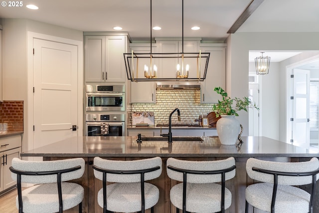 1718 SE 40th St, Brush Prairie, WA 98606 - kitchen featuring a chandelier, tasteful backsplash, recessed lighting, double oven, and a breakfast bar area