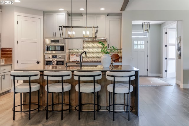 1718 SE 40th St, Brush Prairie, WA 98606 - kitchen featuring a chandelier, double oven, backsplash, recessed lighting, and a center island with sink