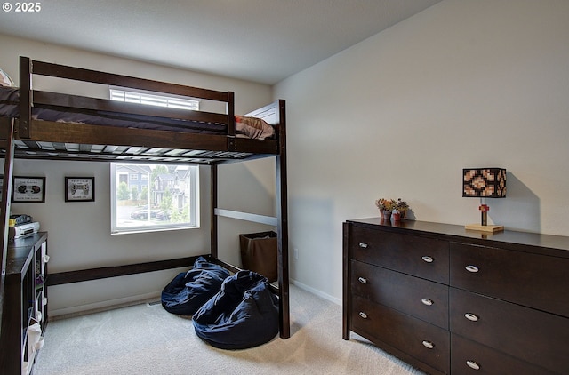 bedroom featuring light carpet and baseboards