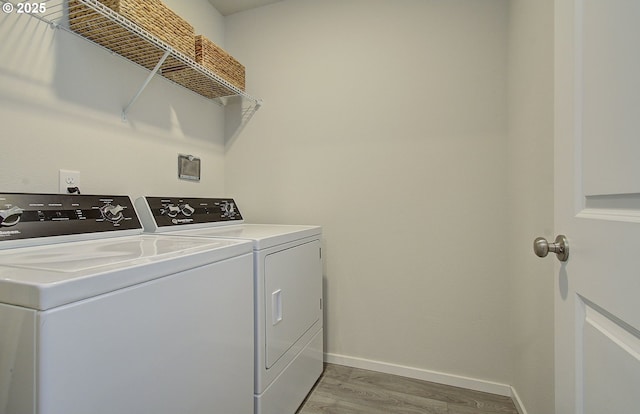 washroom with independent washer and dryer, light wood finished floors, and baseboards
