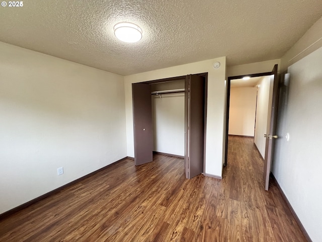 2011/2013 Ohio Ave, North Bend, OR 97459 - unfurnished bedroom with a textured ceiling, dark wood-style flooring, and a closet