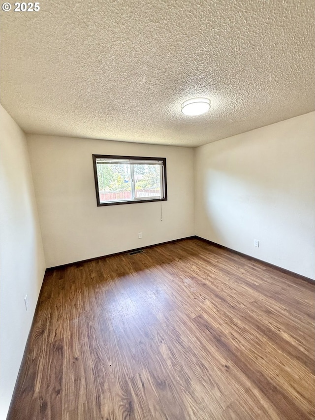 2011/2013 Ohio Ave, North Bend, OR 97459 - unfurnished room with a textured ceiling and wood finished floors