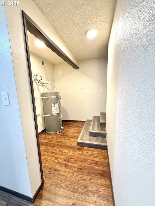 2011/2013 Ohio Ave, North Bend, OR 97459 - hallway with strapped water heater, a textured ceiling, wood finished floors, and a textured wall