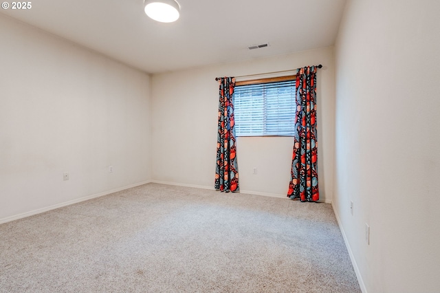 carpeted empty room featuring visible vents and baseboards