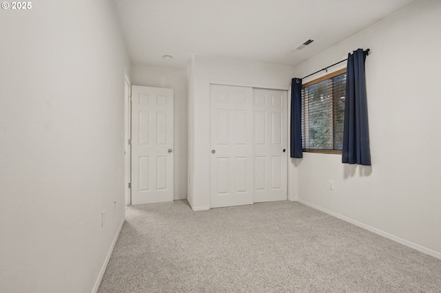 unfurnished bedroom featuring visible vents, carpet flooring, a closet, and baseboards