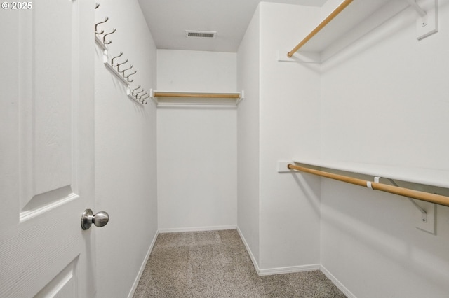 walk in closet featuring visible vents and light carpet
