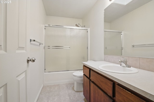 full bath with shower / bath combination with glass door, toilet, tile patterned flooring, and vanity