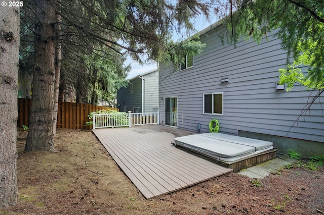 wooden deck featuring fence and a covered hot tub