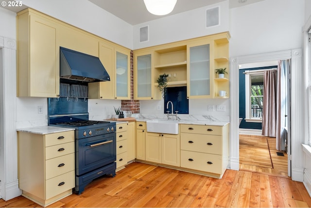 2664 NW Thurman St, Portland, OR 97210 - kitchen with range hood, cream cabinets, black range with gas cooktop, a sink, and backsplash