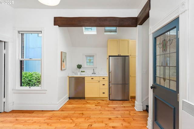 2664 NW Thurman St, Portland, OR 97210 - kitchen featuring stainless steel appliances, light wood-style flooring, baseboards, light countertops, and lofted ceiling