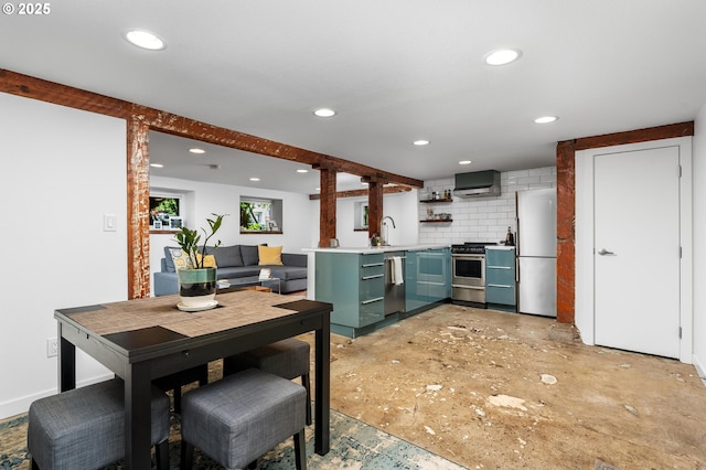 2664 NW Thurman St, Portland, OR 97210 - kitchen with appliances with stainless steel finishes, wall chimney range hood, green cabinetry, recessed lighting, and decorative backsplash