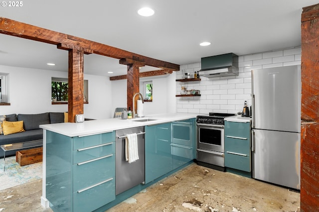 2664 NW Thurman St, Portland, OR 97210 - kitchen with stainless steel appliances, a sink, open shelves, wall chimney range hood, and a peninsula