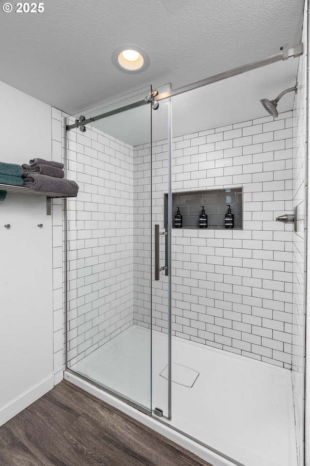 2664 NW Thurman St, Portland, OR 97210 - bathroom featuring a stall shower, wood finished floors, a textured ceiling, baseboards, and recessed lighting