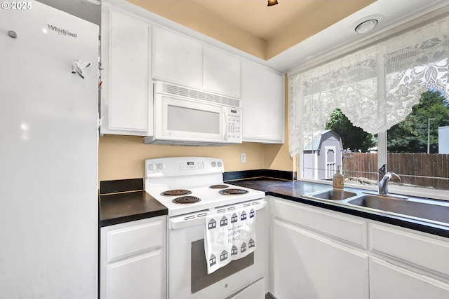 523 65th St, Springfield, OR 97478 - kitchen featuring white appliances, white cabinets, dark countertops, and a sink
