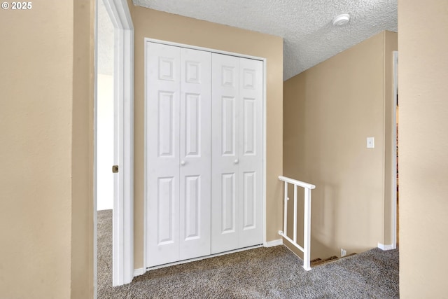 523 65th St, Springfield, OR 97478 - hallway with an upstairs landing, dark carpet, a textured ceiling, and baseboards