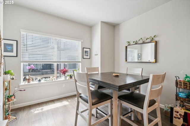dining space with wood finished floors and baseboards