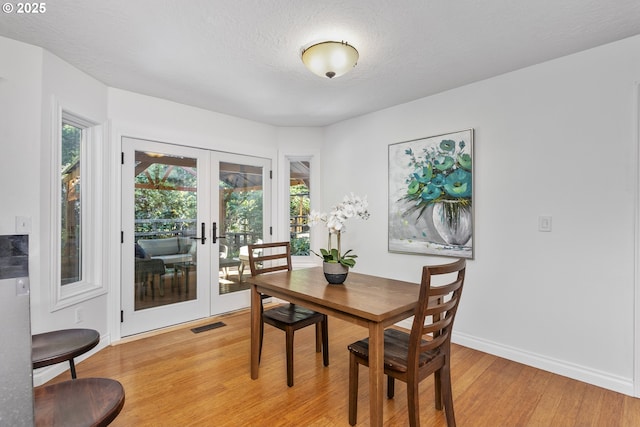 13555 SW Hiteon Ct, Beaverton, OR 97008 - dining area with french doors, light wood-style flooring, and a textured ceiling