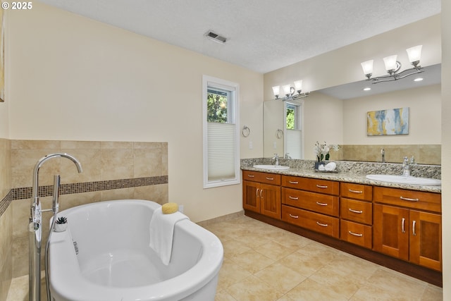 13555 SW Hiteon Ct, Beaverton, OR 97008 - full bath with double vanity, a soaking tub, a textured ceiling, and tile patterned floors