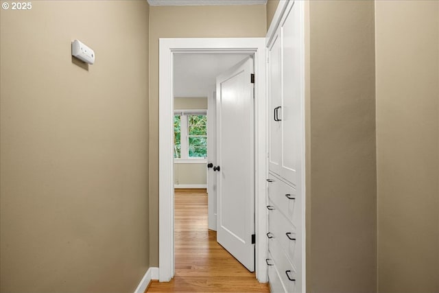 hall with light wood finished floors and baseboards