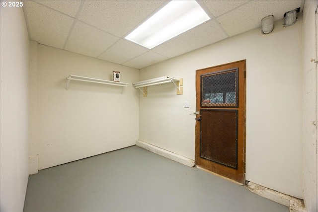 unfurnished room featuring finished concrete floors and a paneled ceiling