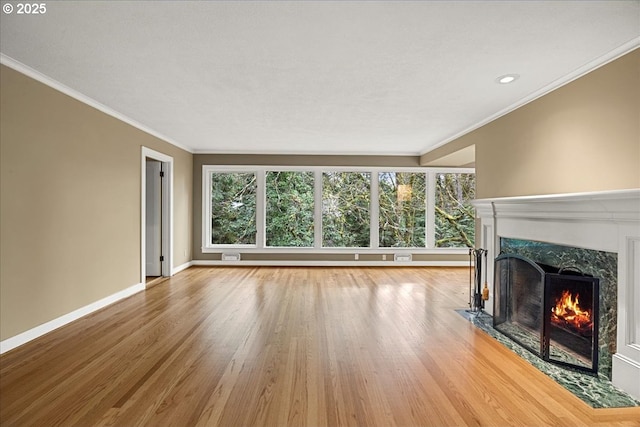 unfurnished living room with a healthy amount of sunlight, a fireplace, baseboards, and wood finished floors