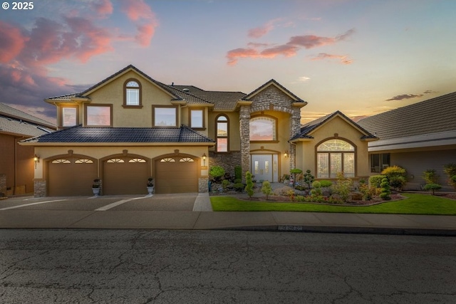 9337 SE Pennington Ct, Happy Valley, OR 97086 - view of front of house featuring stucco siding, driveway, stone siding, and an attached garage