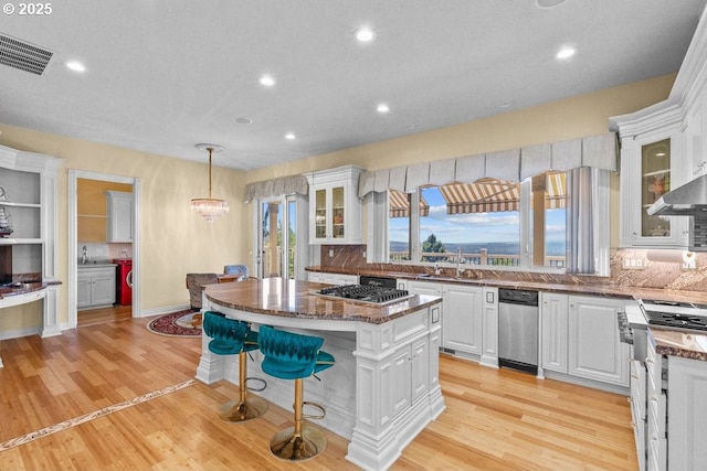 9337 SE Pennington Ct, Happy Valley, OR 97086 - kitchen featuring washer and dryer, a sink, a kitchen island, white cabinetry, and recessed lighting