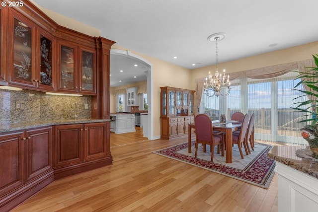 9337 SE Pennington Ct, Happy Valley, OR 97086 - dining area with light wood finished floors, a chandelier, plenty of natural light, arched walkways, and recessed lighting