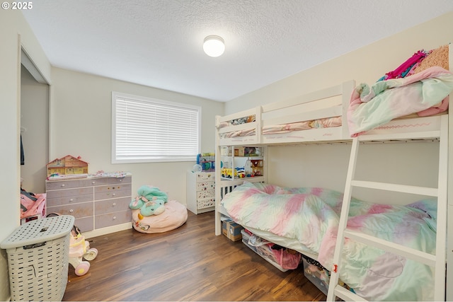 bedroom with a textured ceiling and wood finished floors