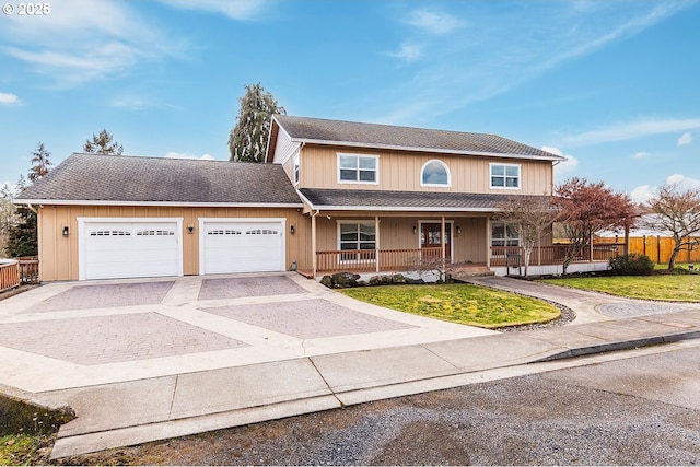 traditional home with covered porch, a front yard, fence, a garage, and driveway