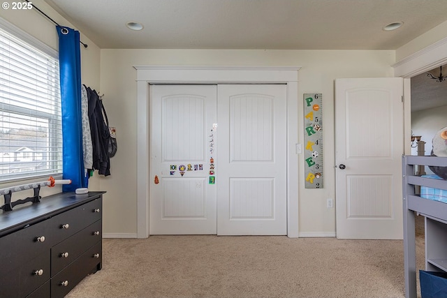 entrance foyer featuring baseboards and light colored carpet