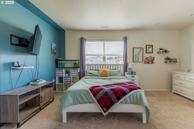 bedroom with light carpet, a textured ceiling, visible vents, and baseboards