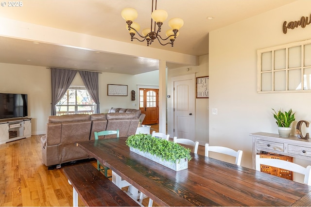 dining room featuring light wood-style flooring and a notable chandelier