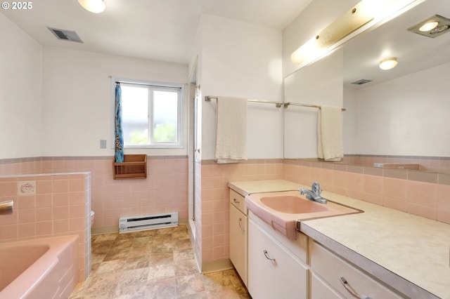 3310 Paula Ct, Eugene, OR 97404 - full bathroom featuring baseboard heating, tile walls, vanity, a garden tub, and a wainscoted wall
