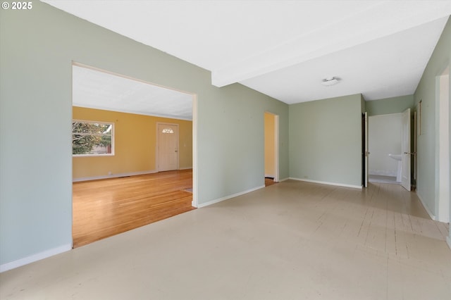 unfurnished room with beam ceiling