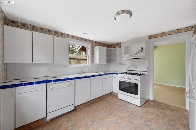 kitchen featuring white cabinets, white appliances, tile counters, and sink