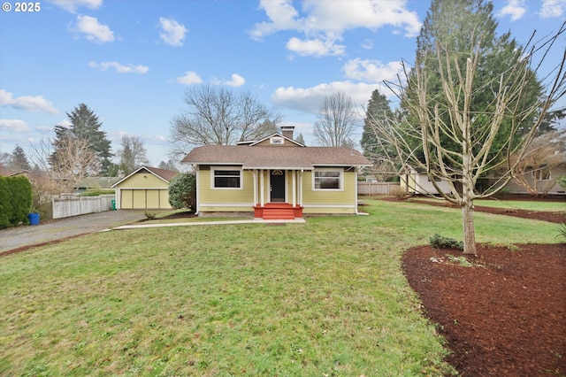 view of front facade with an outbuilding, a front lawn, and a garage