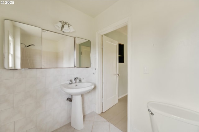 bathroom featuring tile patterned flooring, a shower, toilet, decorative backsplash, and tile walls