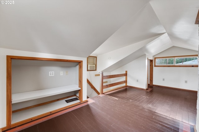 bonus room featuring dark hardwood / wood-style flooring, a wall mounted AC, and lofted ceiling